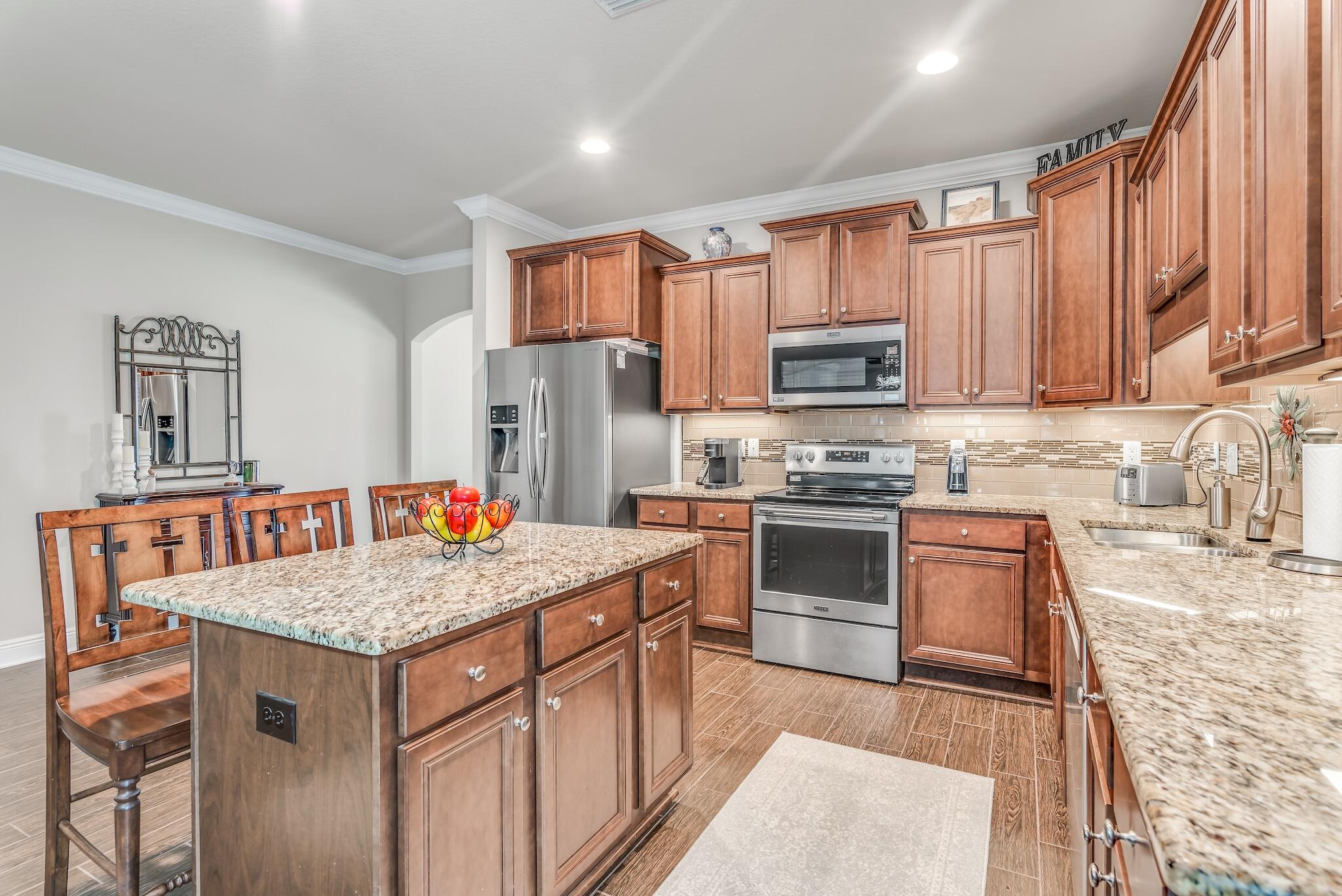 446 Pin Oak Loop Santa Rosa Beach, FL 32459 - Photo 17 of 48 a kitchen with stainless steel appliances granite countertop a stove top oven a refrigerator a sink and dishwasher