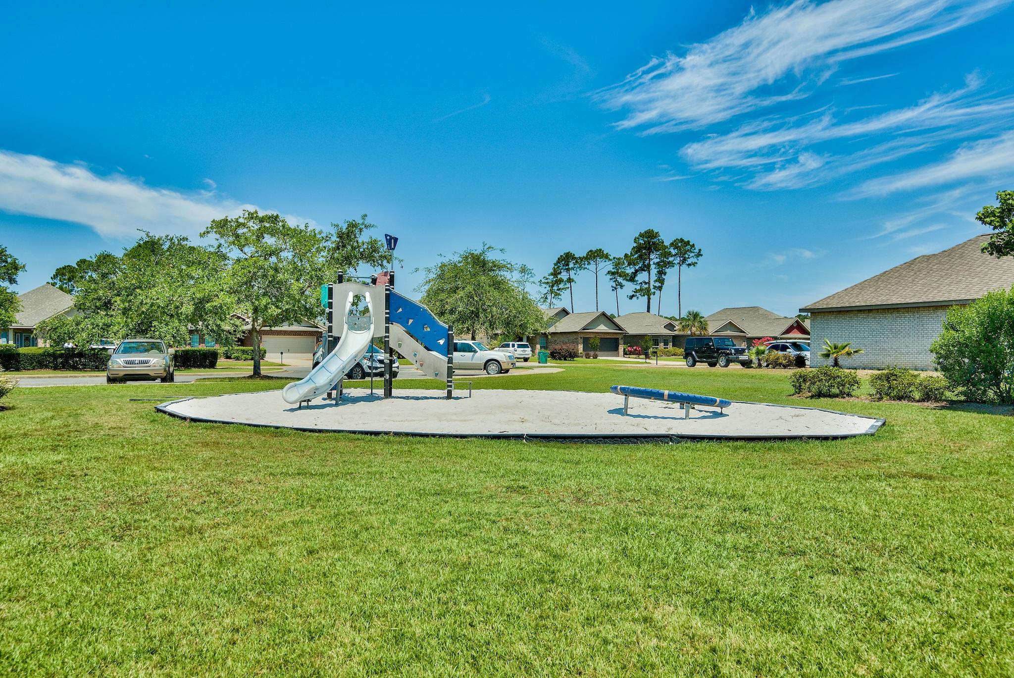 446 Pin Oak Loop Santa Rosa Beach, FL 32459 - Photo 41 of 48 a view of a garden with a bench in the back