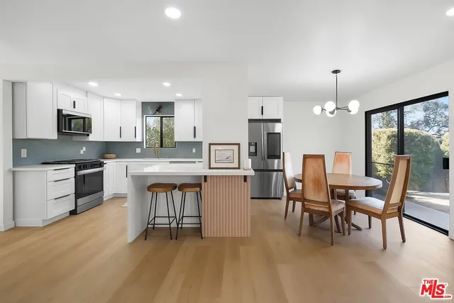 a kitchen with a table chairs microwave and cabinets