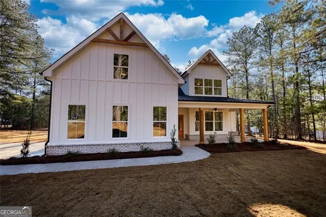 a view of a house with backyard and trees