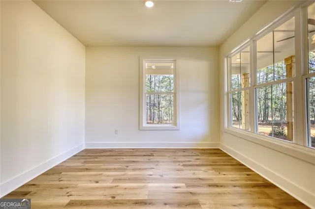 a kitchen with granite countertop a stove top oven a sink a window and white cabinets