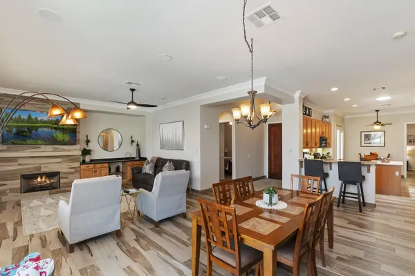 a view of a dining room with furniture a chandelier and wooden floor