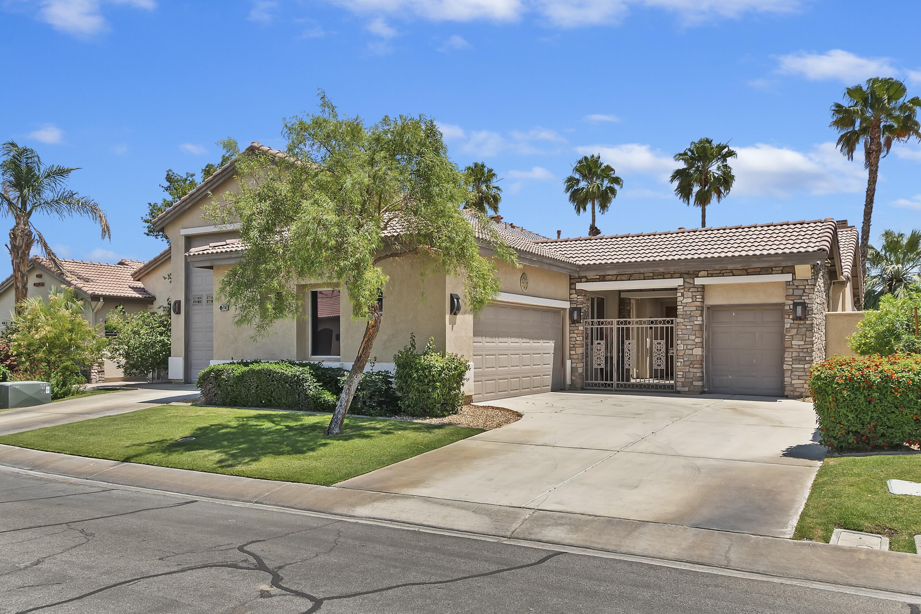 49714 Newman Circle Indio, CA 92201 - Photo 17 of 19 a front view of a house with a yard and potted plants