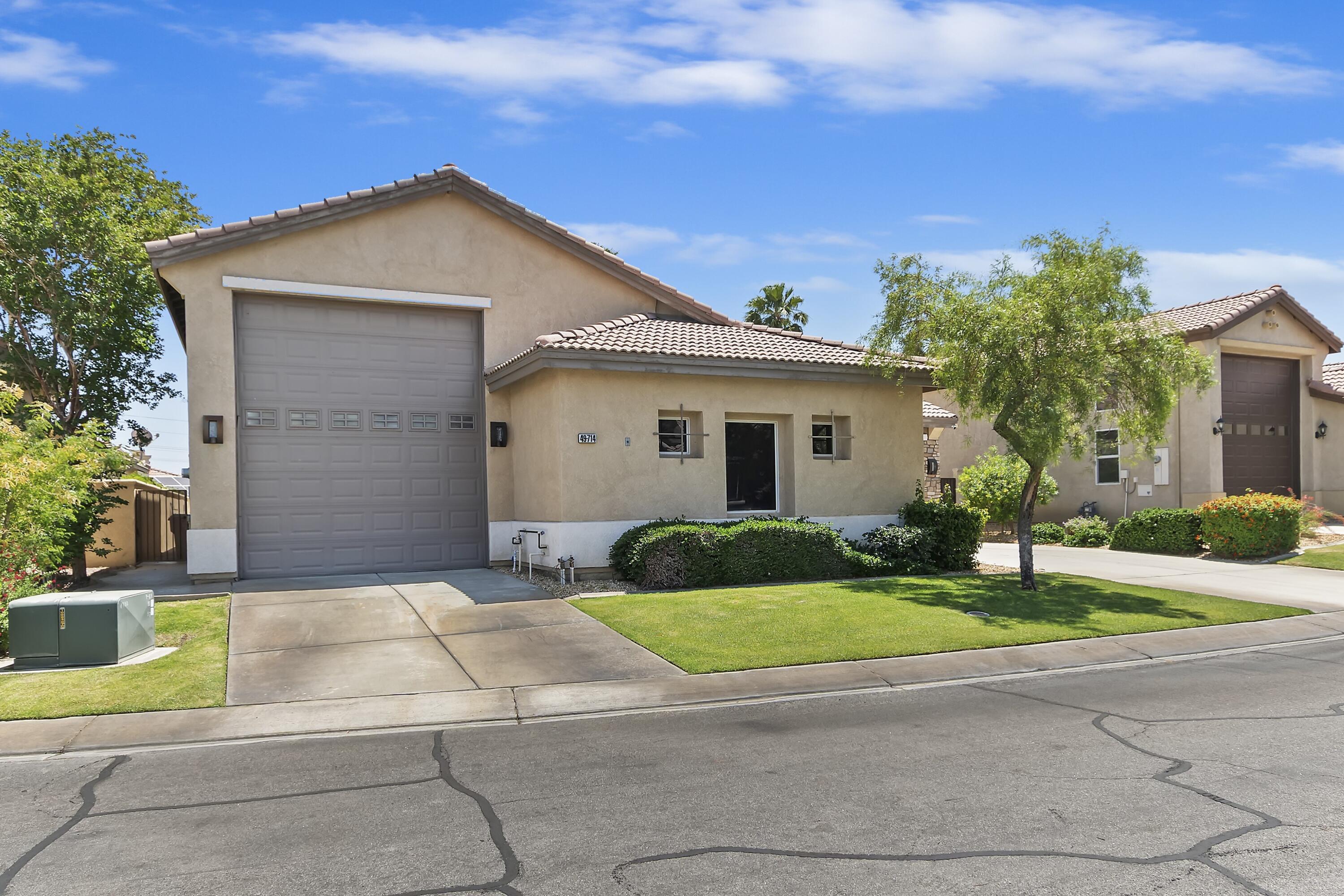 49714 Newman Circle Indio, CA 92201 - Photo 18 of 19 a front view of a house with a yard and garage