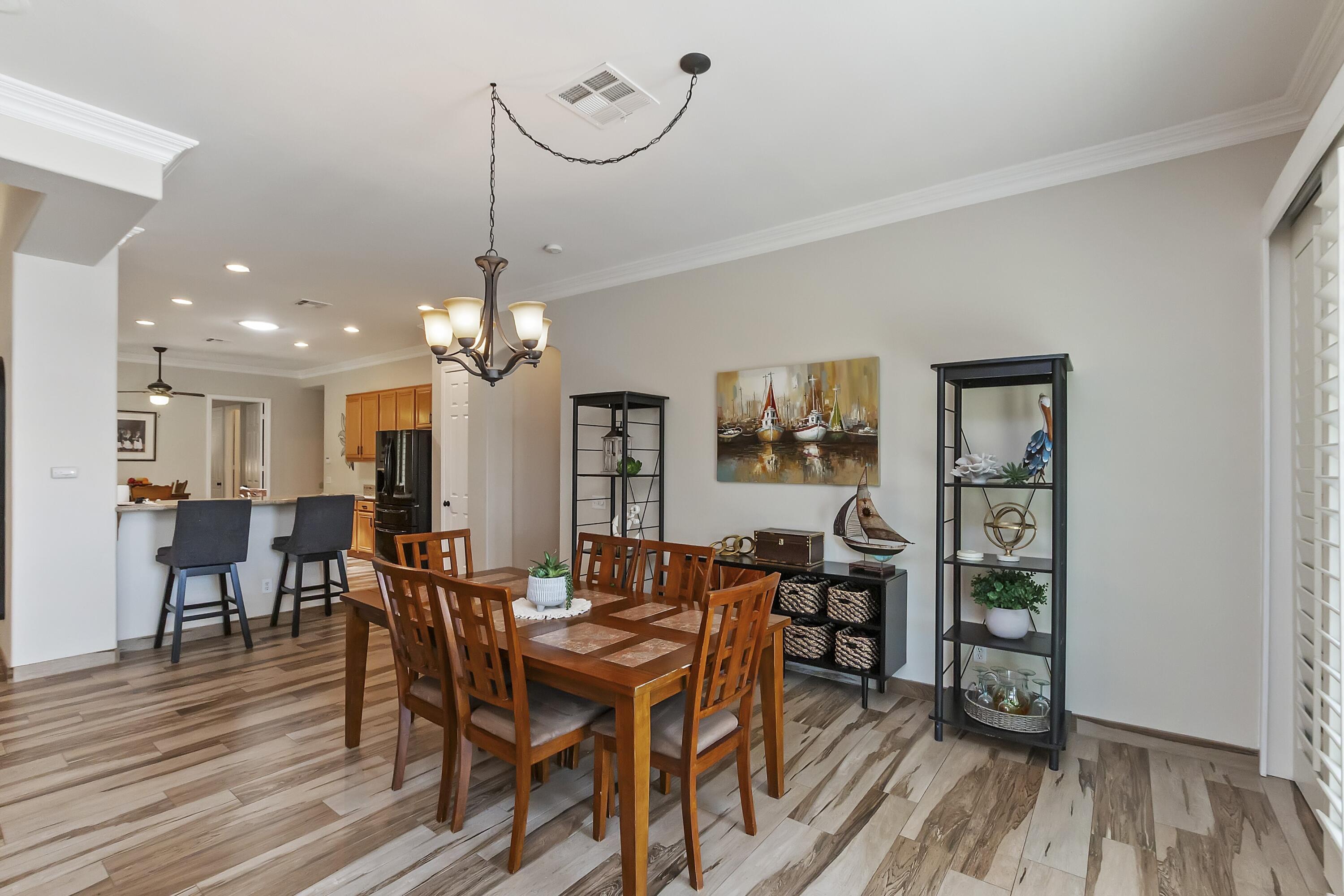 49714 Newman Circle Indio, CA 92201 - Photo 3 of 19 a view of a dining room with furniture wooden floor and chandelier