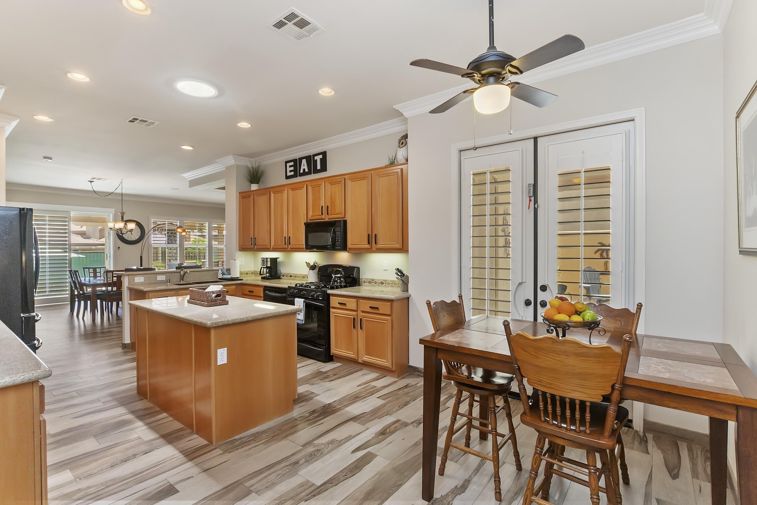 49714 Newman Circle Indio, CA 92201 - Photo 4 of 19 a kitchen with a stove a refrigerator and a dining table