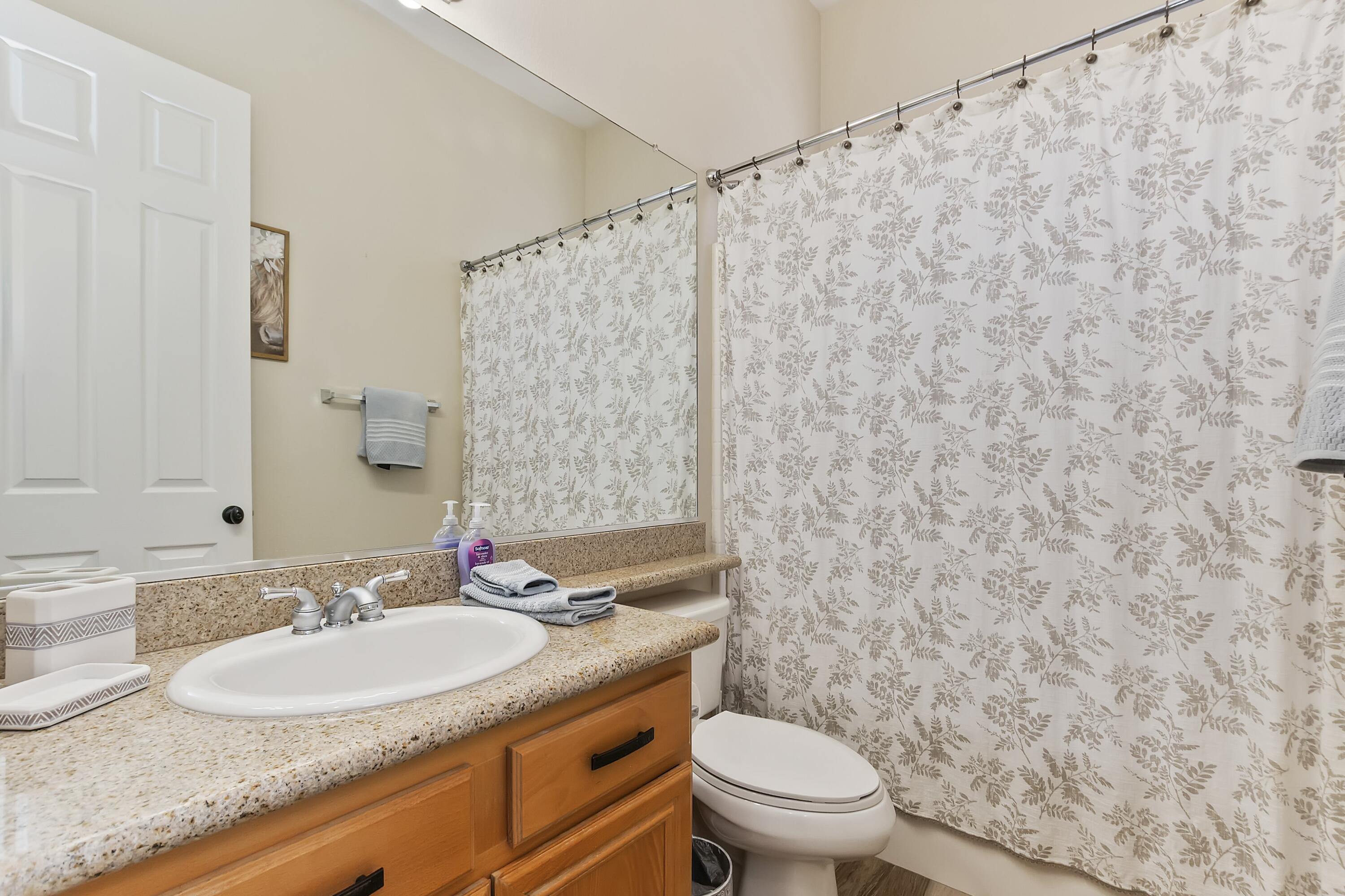 49714 Newman Circle Indio, CA 92201 - Photo 10 of 19 a bathroom with a granite countertop sink and a mirror