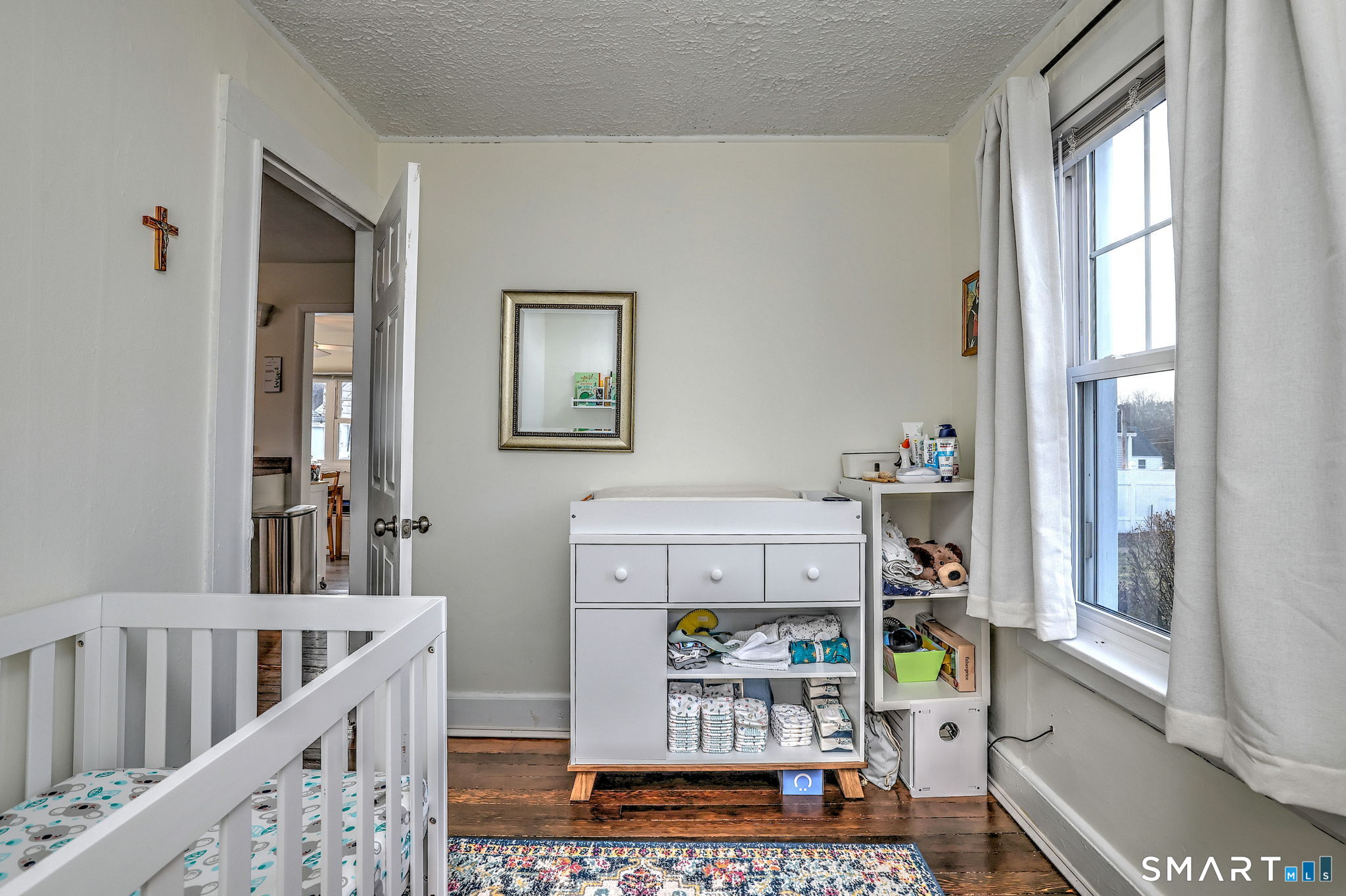 299 Meadows End Road Milford, CT 06460 - Photo 19 of 27 a room with furniture a baby crib and a window