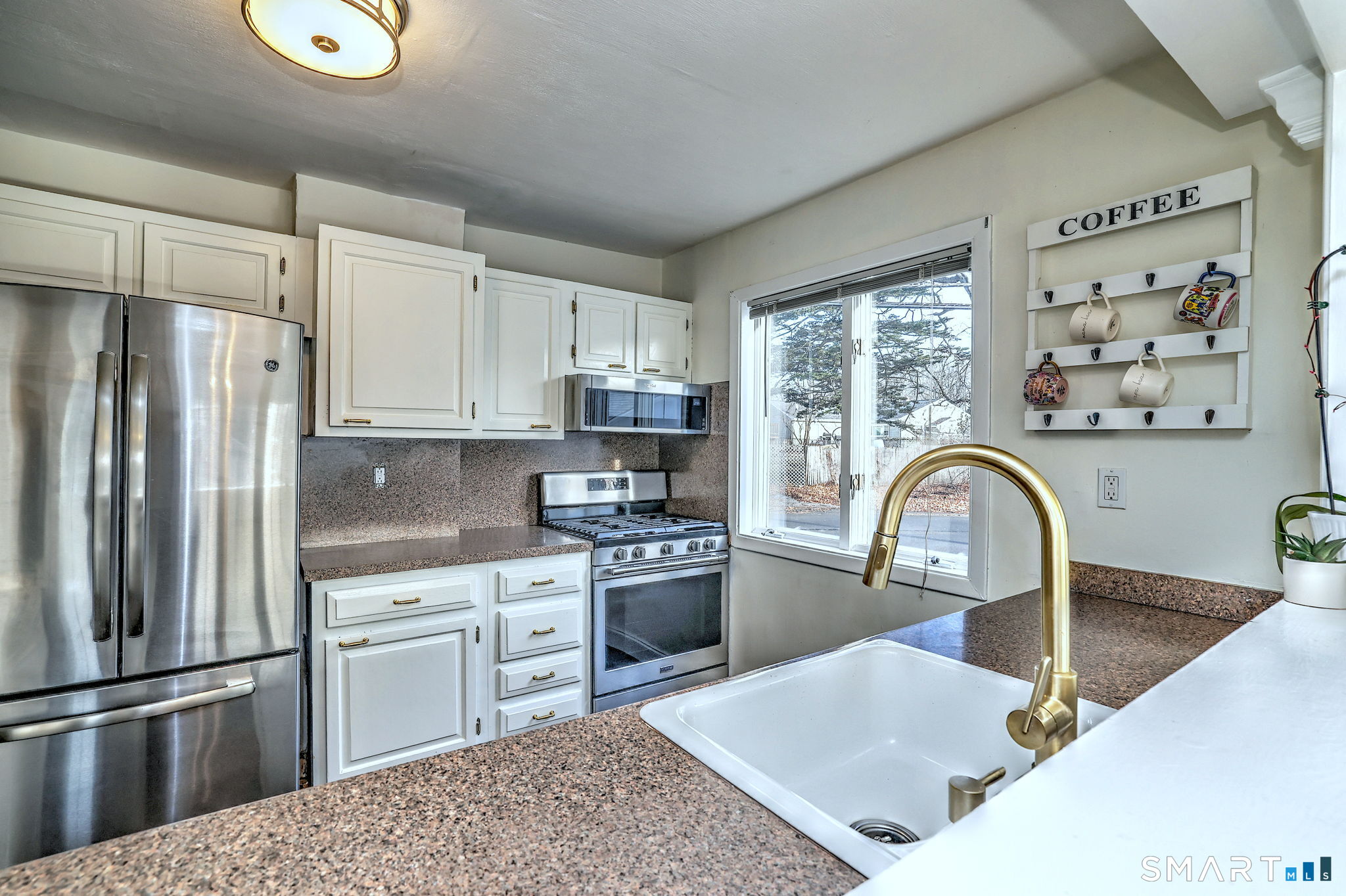 299 Meadows End Road Milford, CT 06460 - Photo 10 of 27 a kitchen with stainless steel appliances granite countertop a refrigerator sink and stove