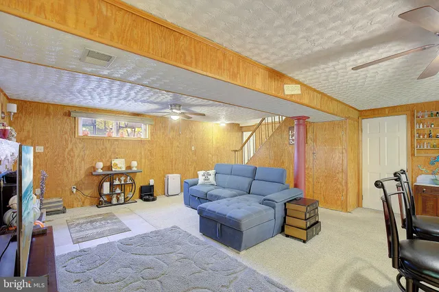 a living room with furniture and view of kitchen