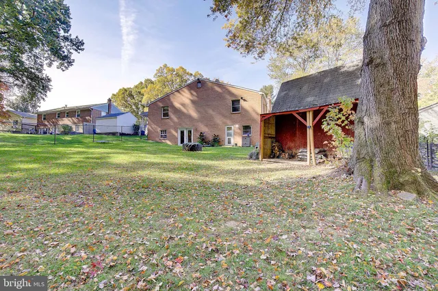 a front view of house with yard and trees in the background