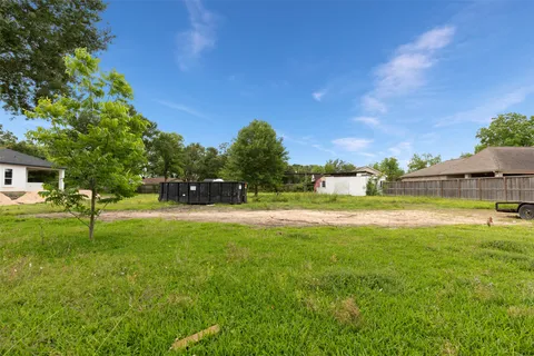 a view of yard with swimming pool and trees in the background