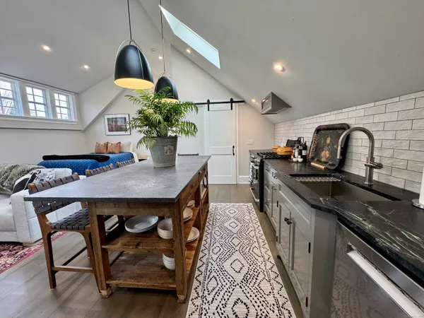 a kitchen with stainless steel appliances granite countertop a sink a stove and a wooden floors