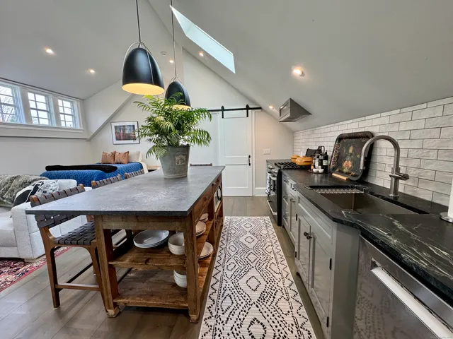 a kitchen with stainless steel appliances granite countertop a sink a stove and a wooden floors