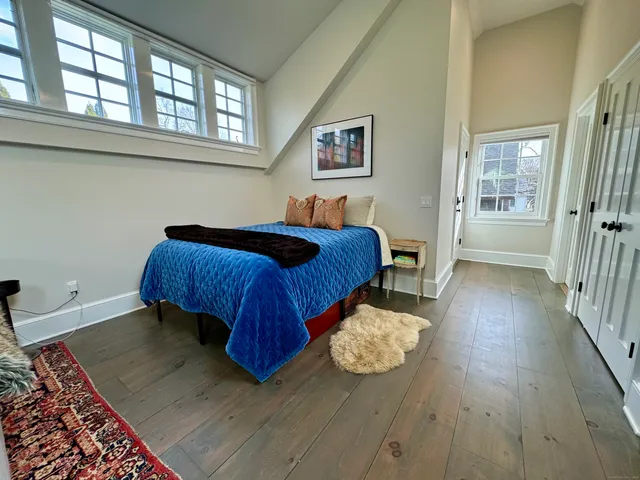 a bedroom with a bed and wooden floor