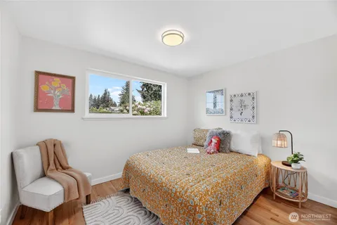 a bedroom with a bed and painting on the wall