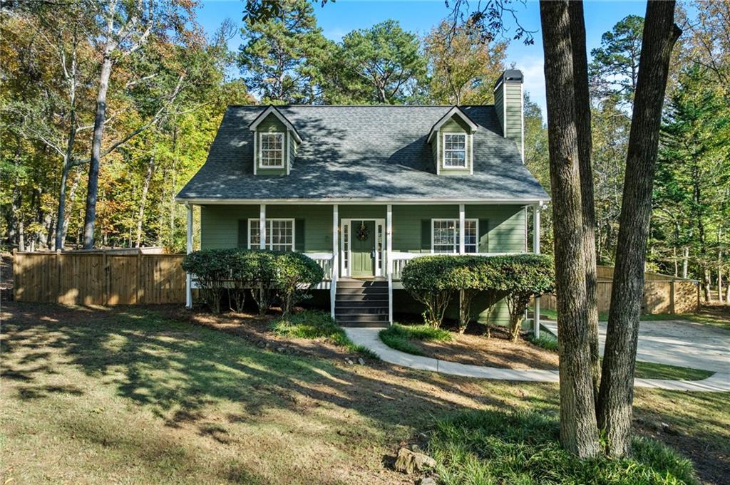 a view of house with a yard and sitting area