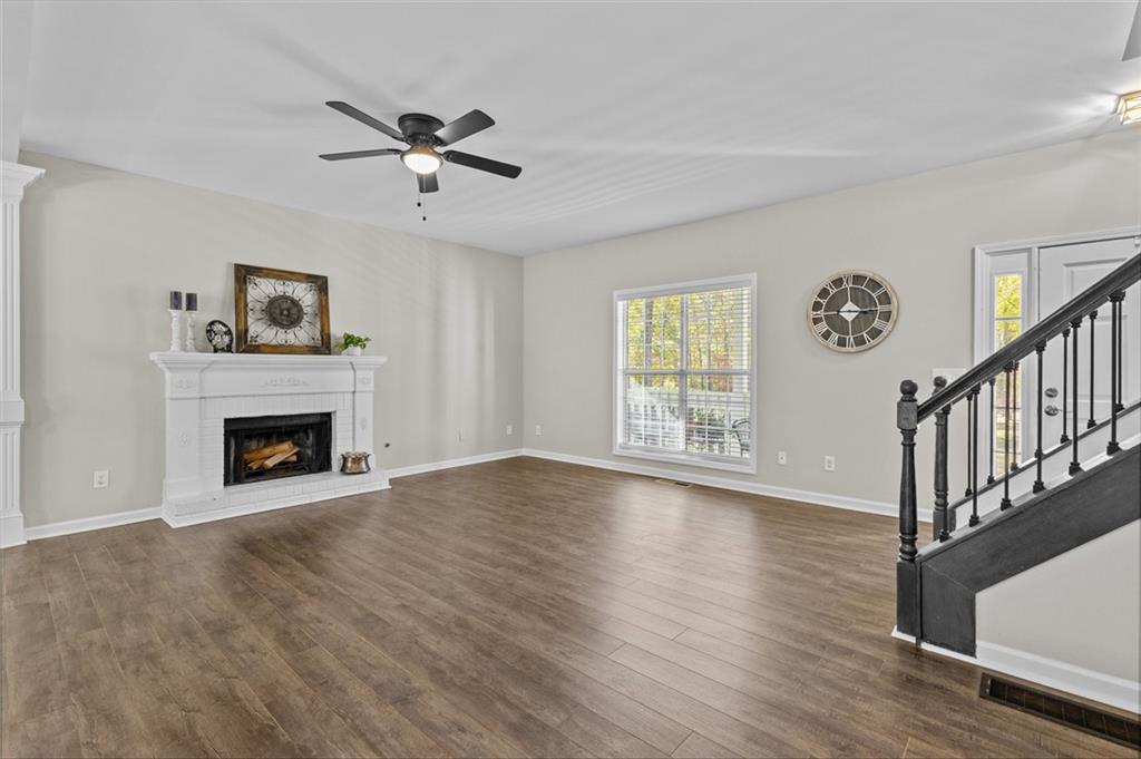 4230 Jonathan Lane Cumming, GA 30040 - Photo 11 of 57 a view of an empty room with wooden floor fireplace and a window