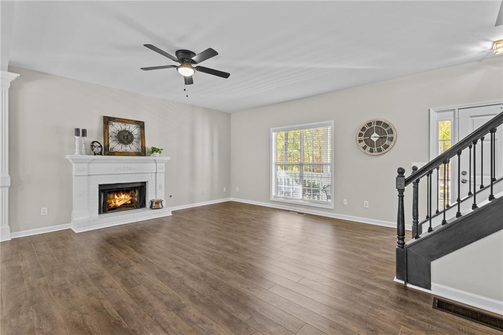 4230 Jonathan Lane Cumming, GA 30040 - Photo 12 of 57 a view of an empty room with wooden floor fireplace and a window