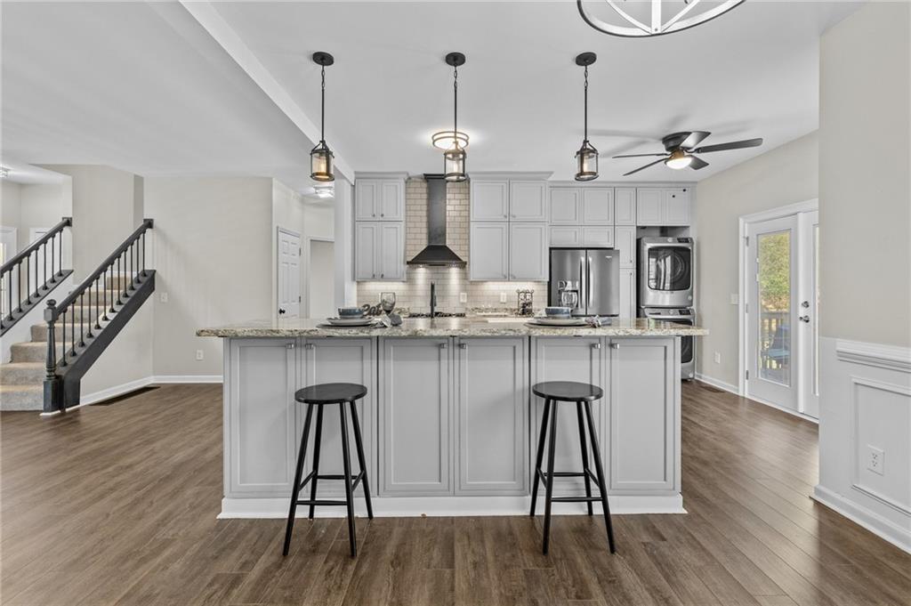 4230 Jonathan Lane Cumming, GA 30040 - Photo 14 of 57 a kitchen with stainless steel appliances granite countertop a kitchen island a stove a refrigerator and a wooden floors