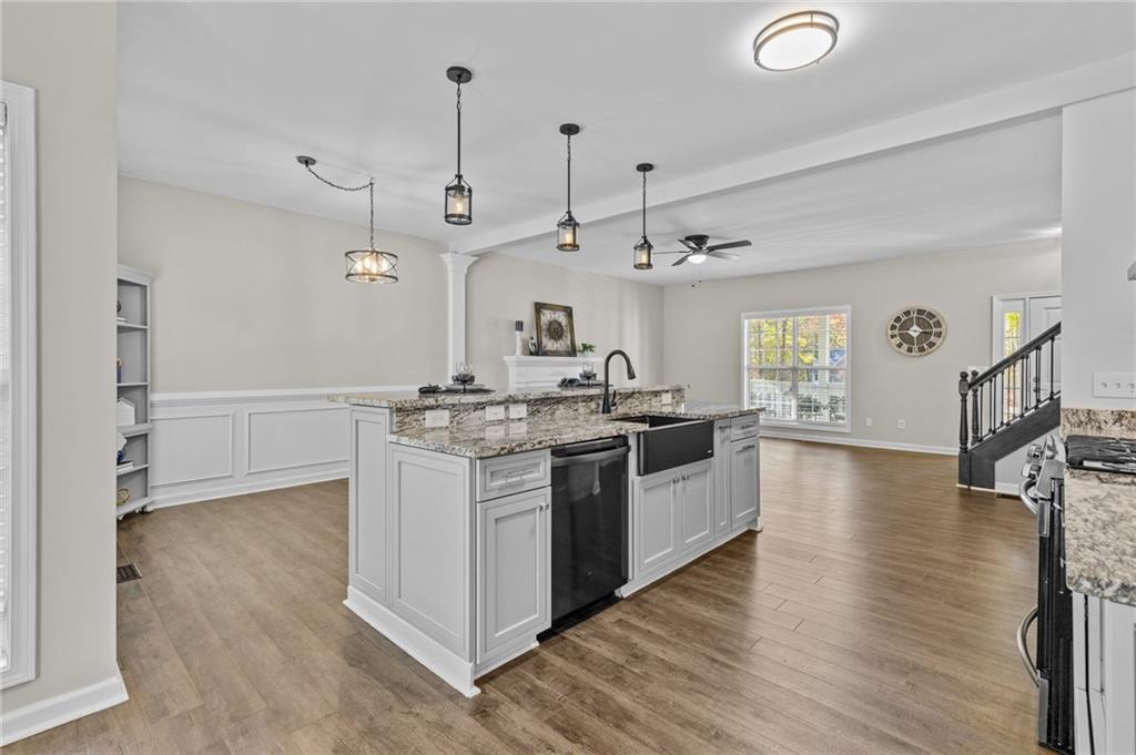 4230 Jonathan Lane Cumming, GA 30040 - Photo 15 of 57 a kitchen with stainless steel appliances granite countertop a sink cabinets and wooden floor