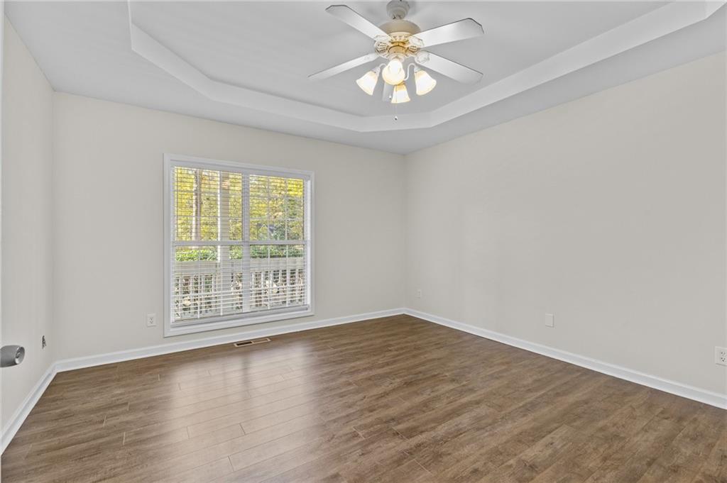 4230 Jonathan Lane Cumming, GA 30040 - Photo 21 of 57 an empty room with wooden floor and windows