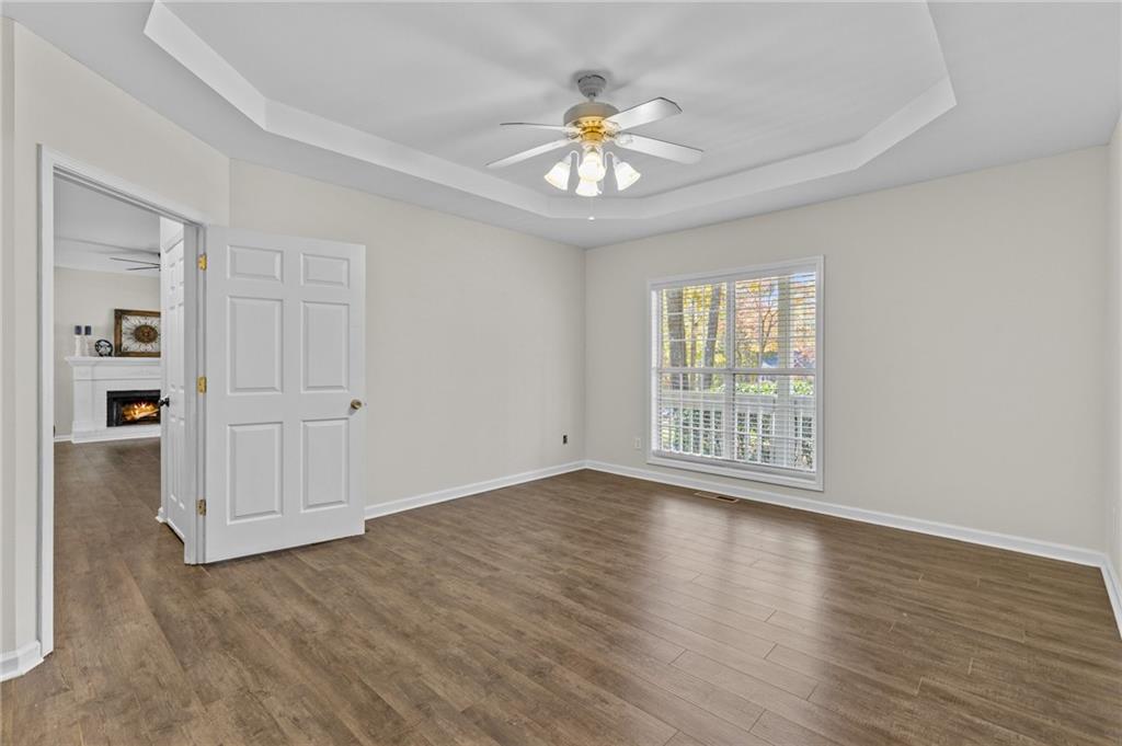 4230 Jonathan Lane Cumming, GA 30040 - Photo 23 of 57 a view of an empty room with a window and wooden floor