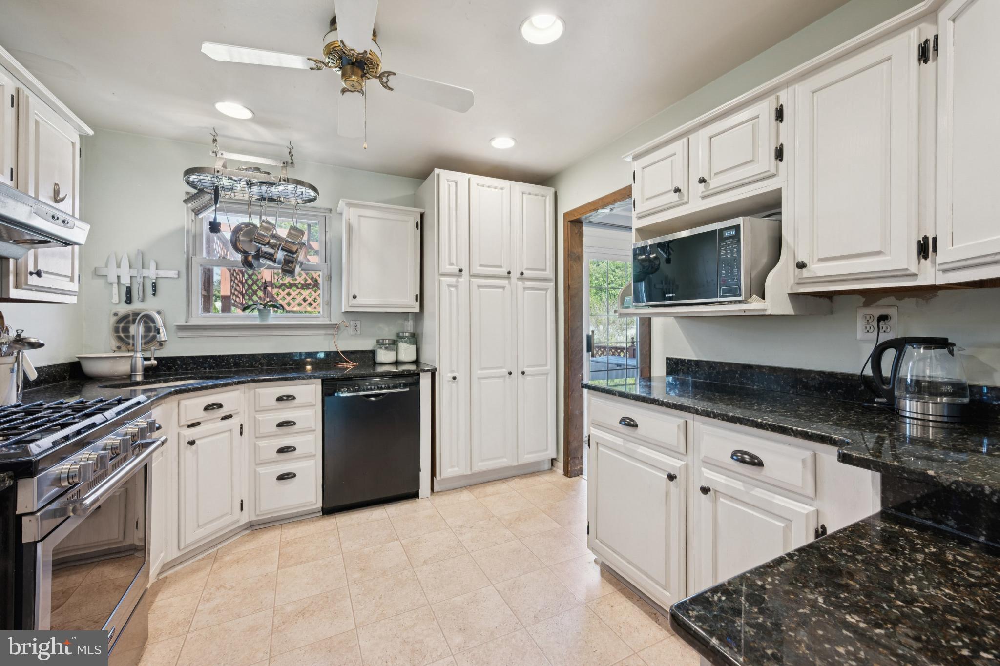 43 Princeton Drive Delran, NJ 08075 - Photo 9 of 25 a kitchen with stainless steel appliances granite countertop a refrigerator a stove a sink dishwasher and white cabinets with wooden floor