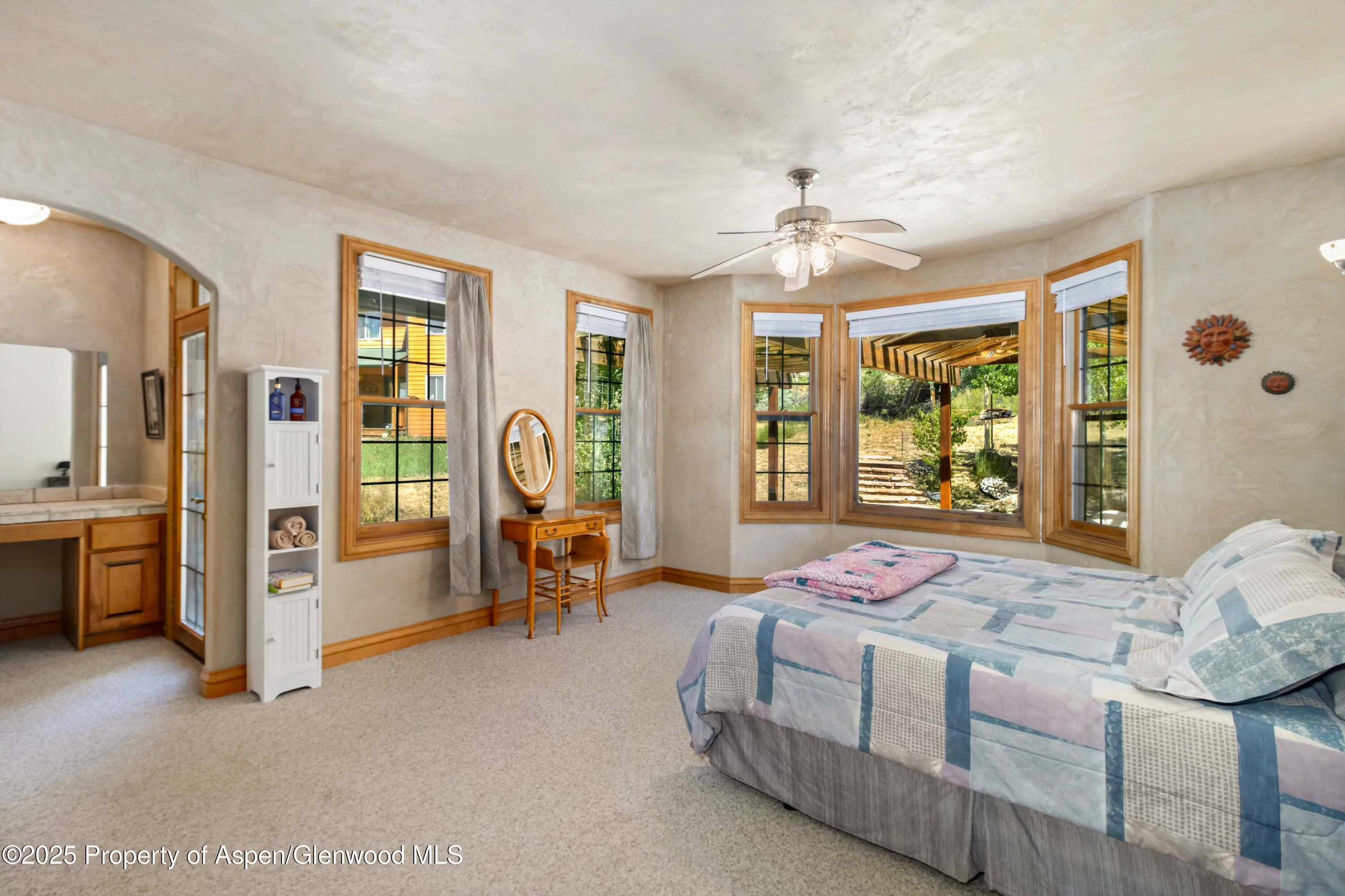 2687 Fairview Heights Court Rifle, CO 81650 - Photo 14 of 40 a spacious bedroom with a bed and a chandelier