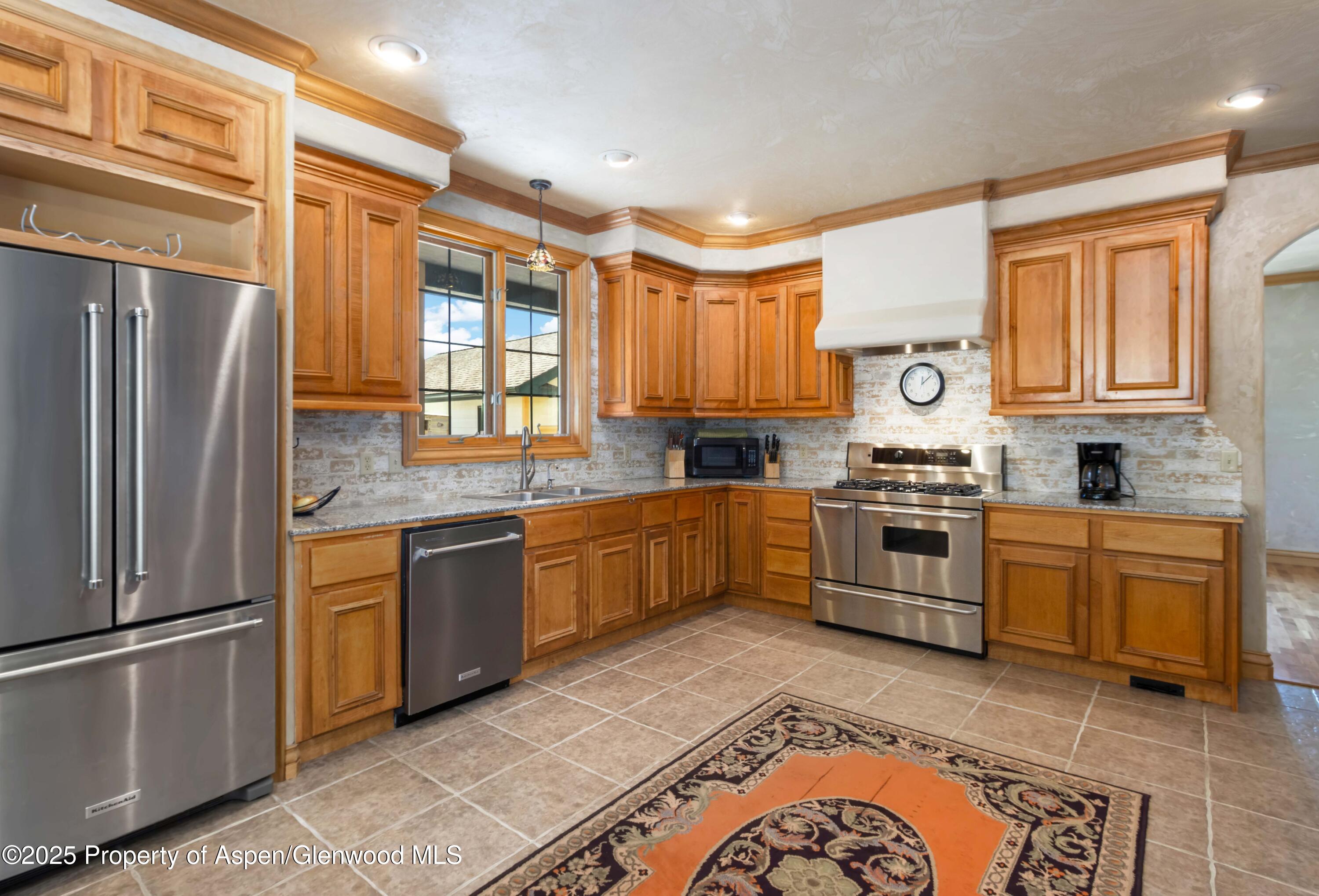 2687 Fairview Heights Court Rifle, CO 81650 - Photo 10 of 40 a kitchen with granite countertop stainless steel appliances a refrigerator sink and microwave
