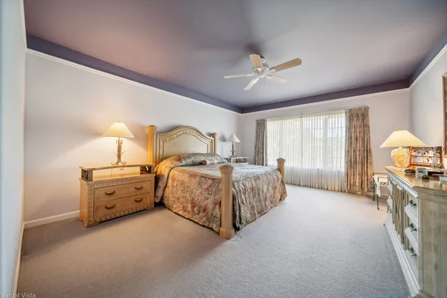 a spacious bedroom with a bed and a chandelier
