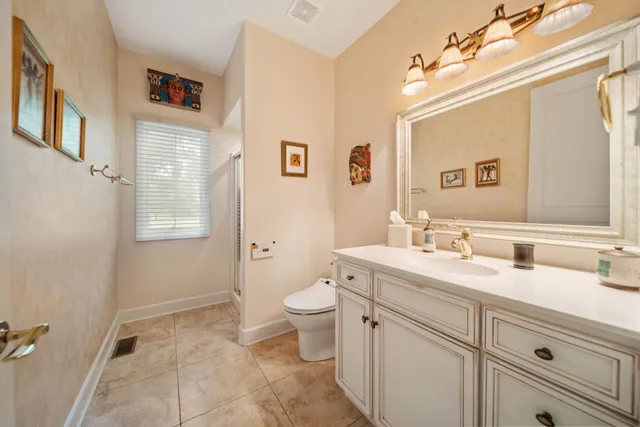 a spacious bathroom with a toilet sink and mirror