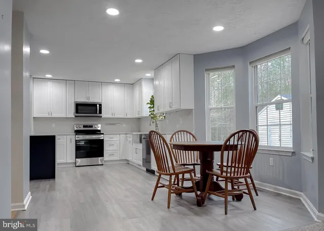 a kitchen with white cabinets stainless steel appliances and sink