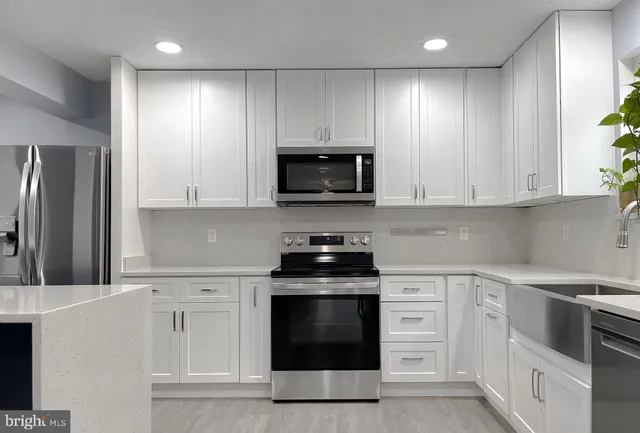 a kitchen with stainless steel appliances kitchen island granite countertop a stove and a microwave
