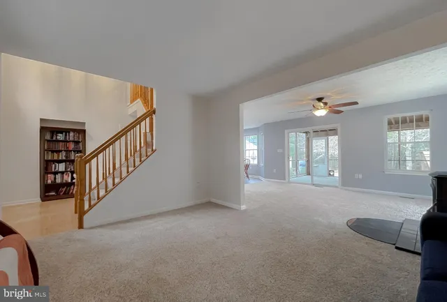 a view of an empty room with windows & lounge chair