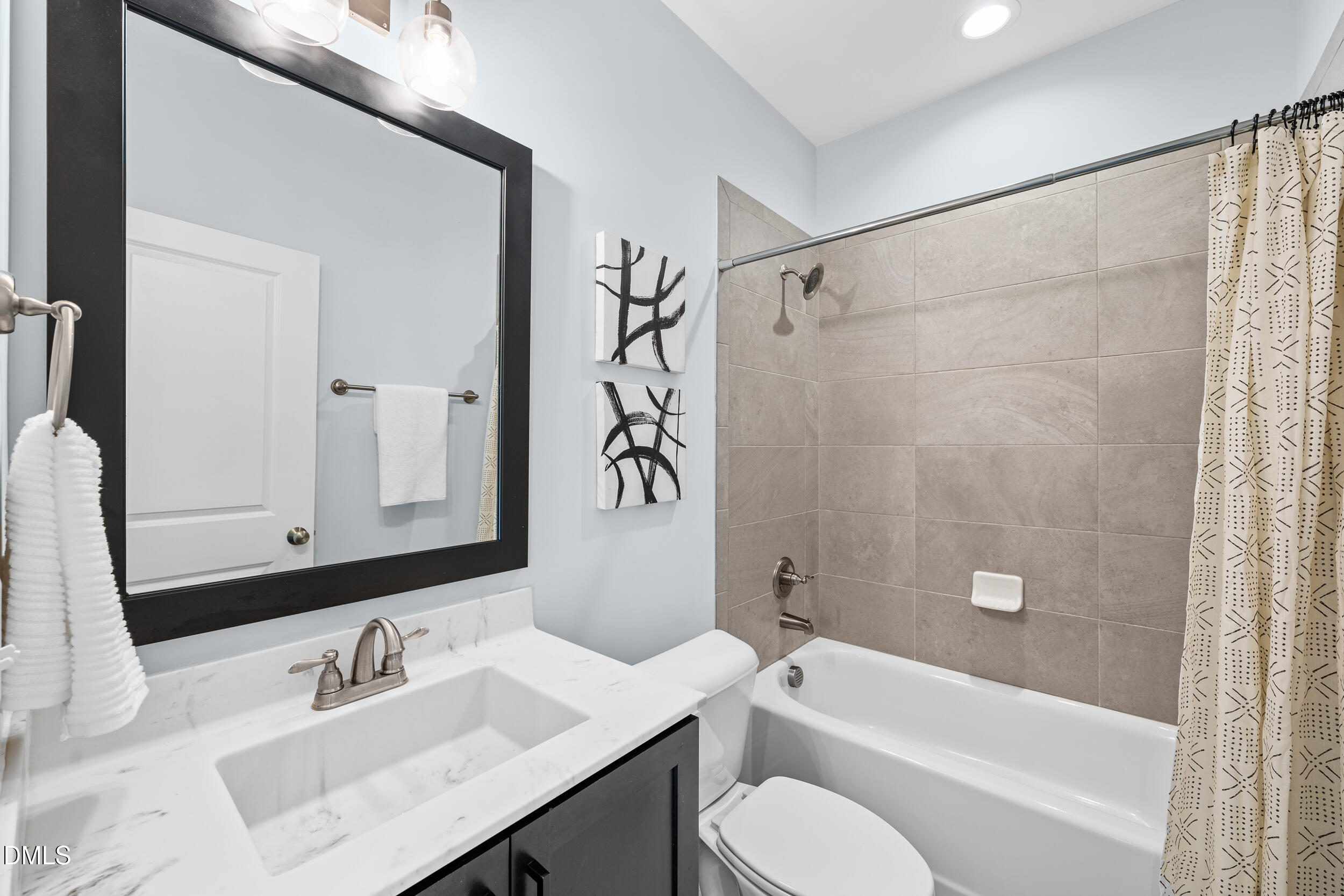 1606 Wooster Street Raleigh, NC 27607 - Photo 23 of 26 a bathroom with a sink a toilet a mirror a bathtub and shower