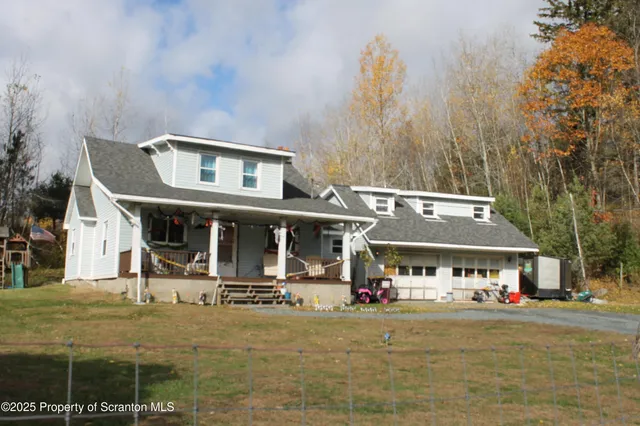 a front view of house with yard and trees in the background