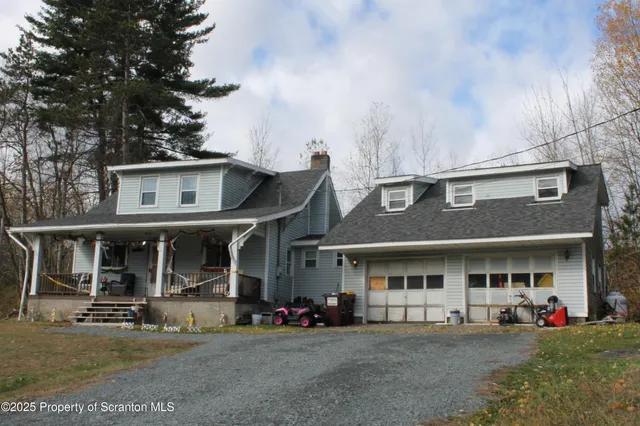 a view of a house with sitting area and covered with tall trees