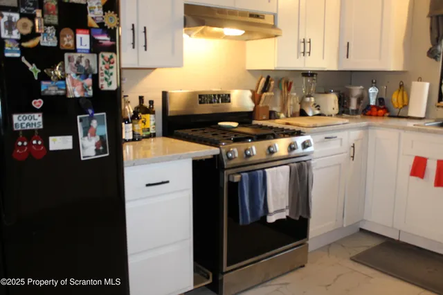 a kitchen with stainless steel appliances granite countertop a stove and a refrigerator