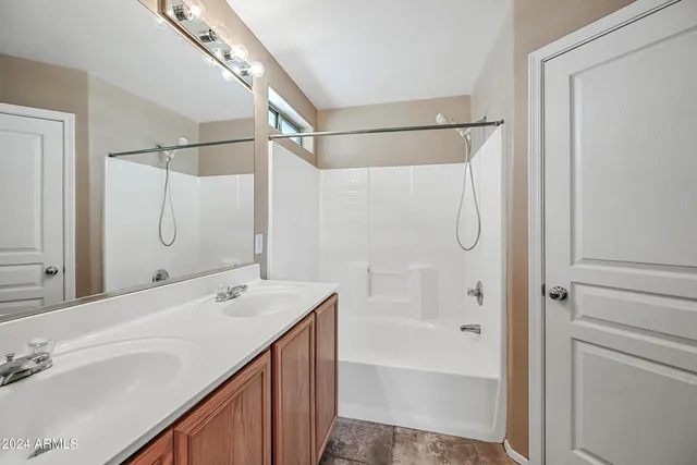 a bathroom with a tub sink shower and mirror
