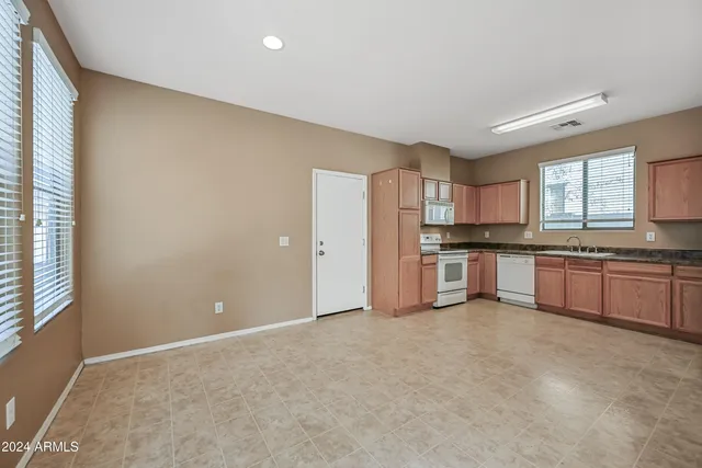 a large kitchen with stainless steel appliances a refrigerator and a stove top oven