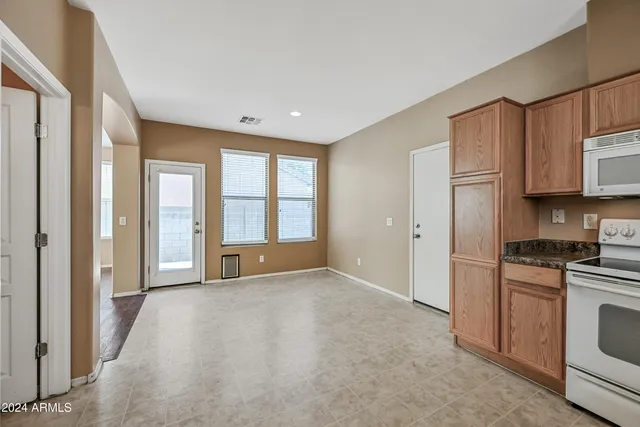 a view of a kitchen with a sink and dishwasher a refrigerator with white cabinets