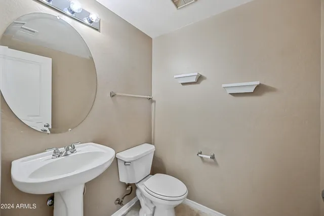 a bathroom with a sink a toilet and mirror