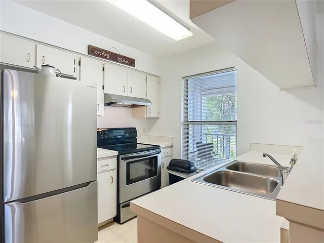 a kitchen with stainless steel appliances a refrigerator sink and stove
