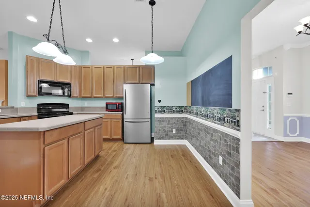 a kitchen with kitchen island a counter top space a sink and stainless steel appliances