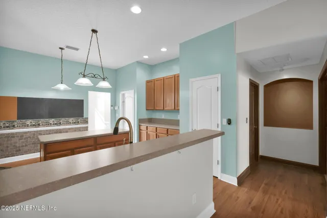 a view of a kitchen with a sink and dishwasher with wooden floor