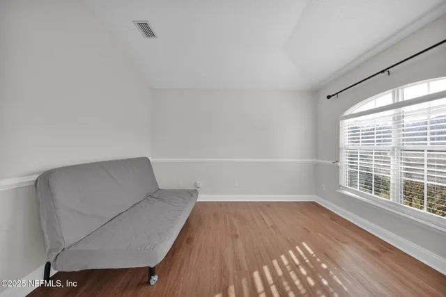 a view of room with window and wooden floor
