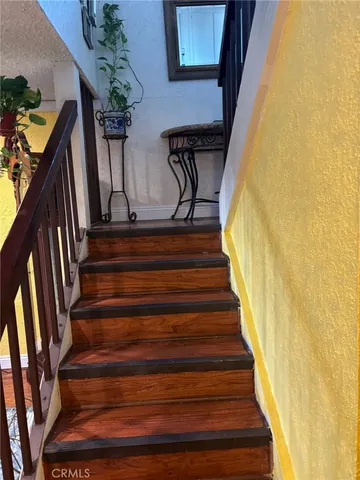 a view of staircase with wooden floor and a potted plant
