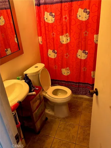 a bathroom with a toilet mirror vanity and sink