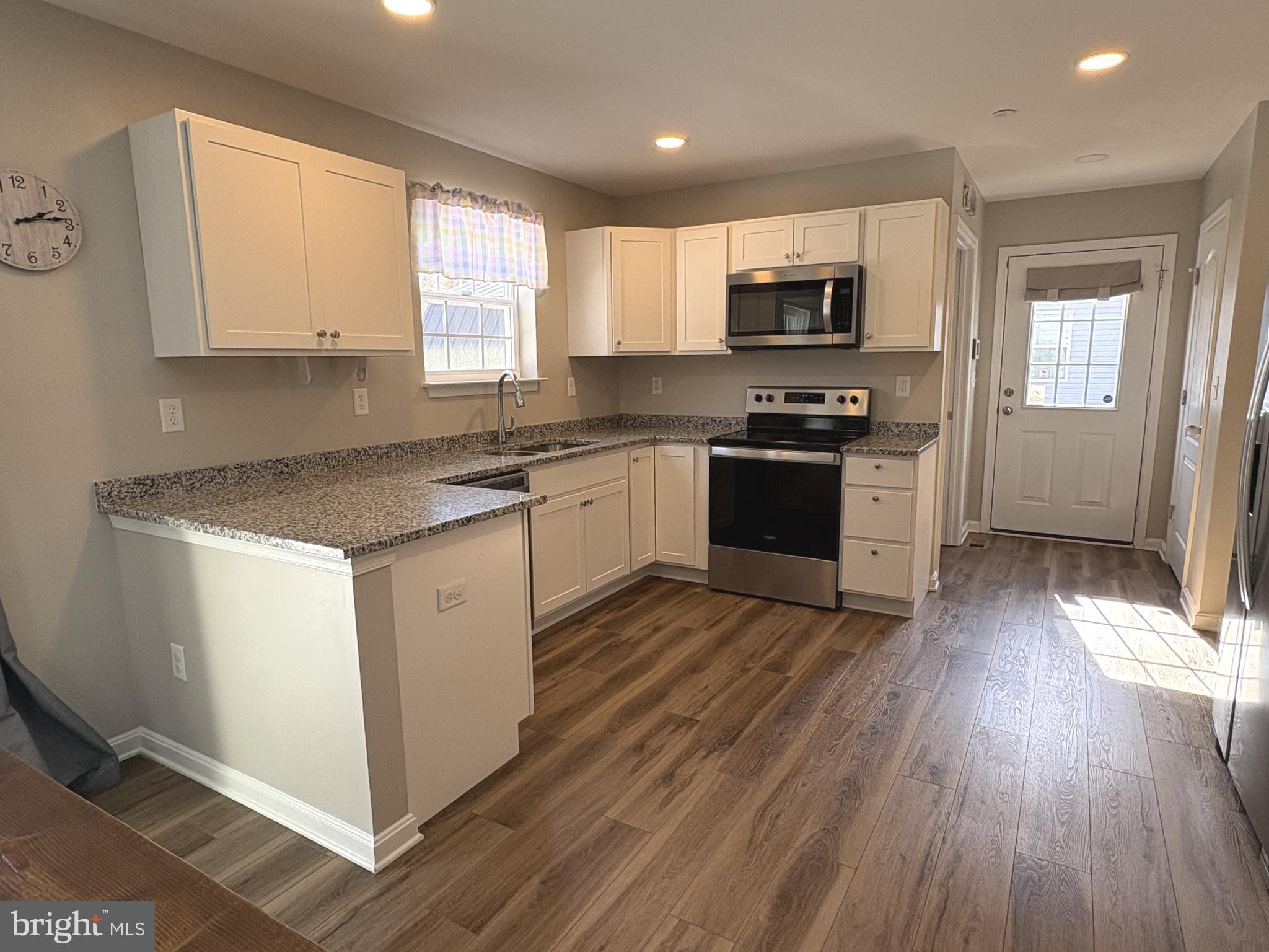 148 East Step Road Chestertown, MD 21620 - Photo 6 of 46 a kitchen with granite countertop a stove top oven a sink dishwasher and a refrigerator with wooden floor
